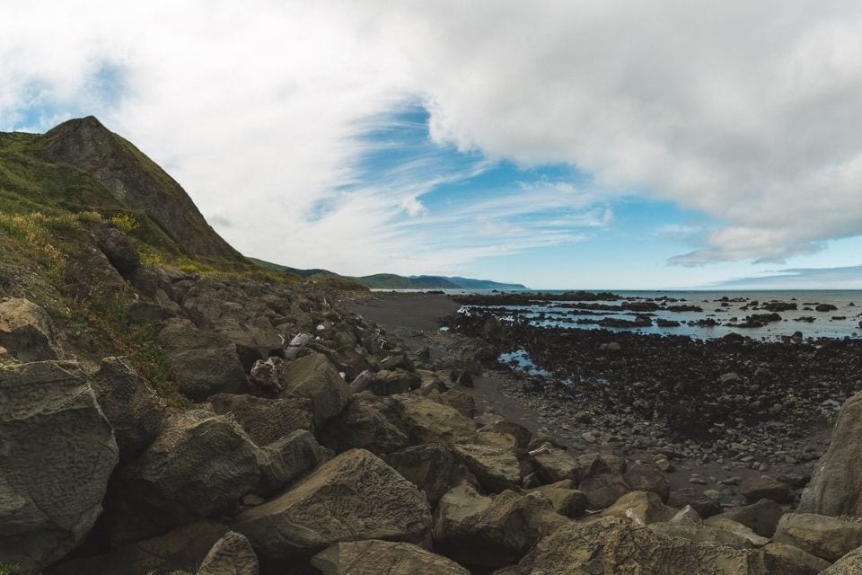 Mountains meet a rocky, dark shoreline on the Lost Coast Trail near Mattole Beach and Mattole Campground.