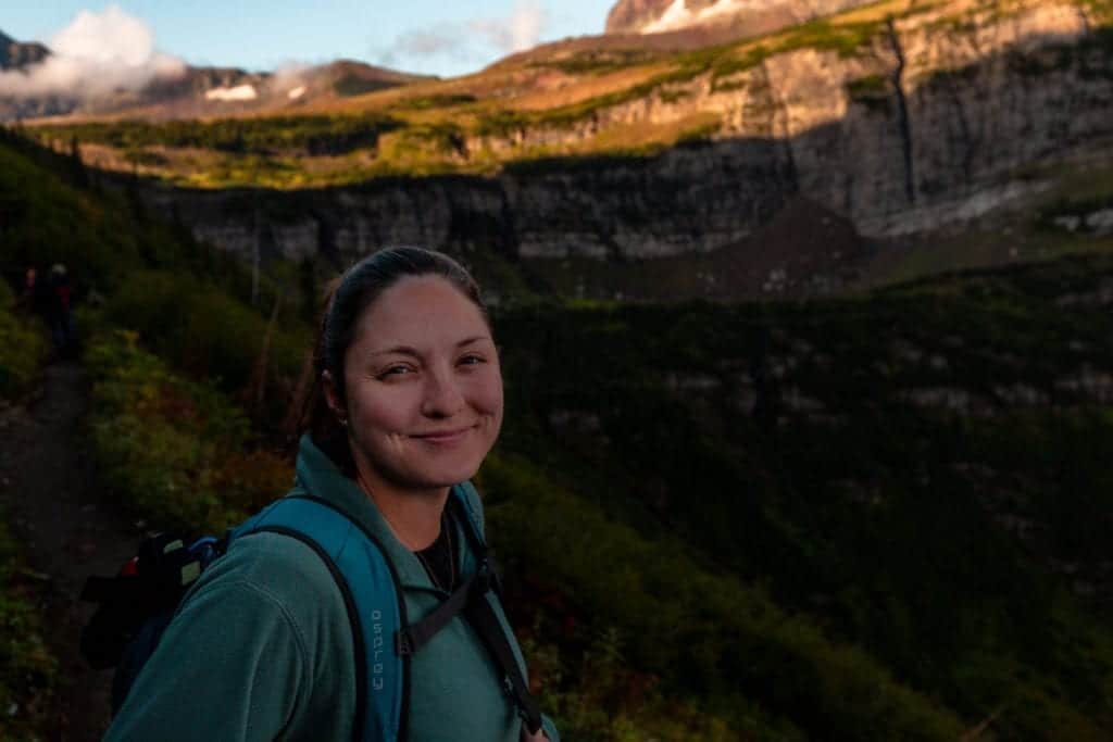 A hiker smiles at the camera along the Highline Trail early in the morning.