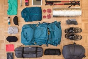 Hiking and camping gear laid out on floor.