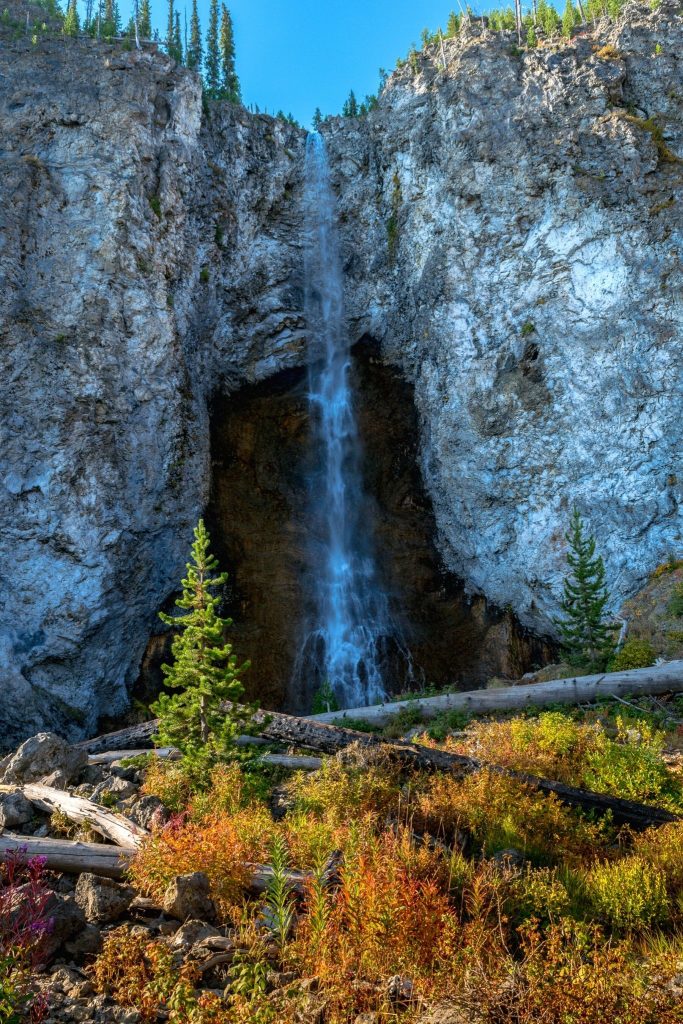 Waterfall in front of a cave and rock wall in Yellowstone