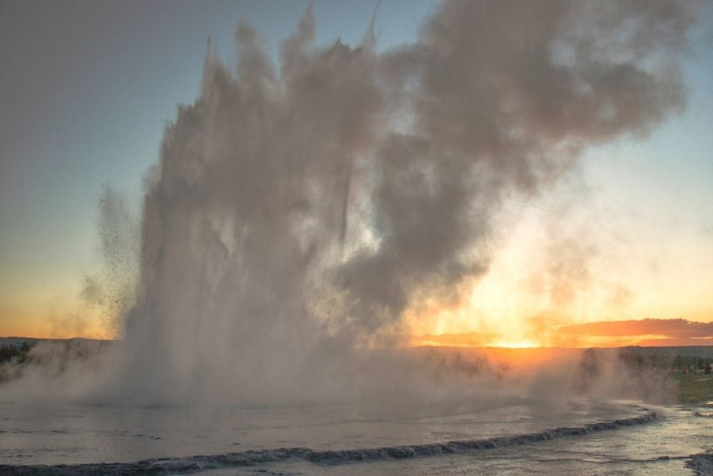 Spewing, tall geyser at sunrise in Yellowstone