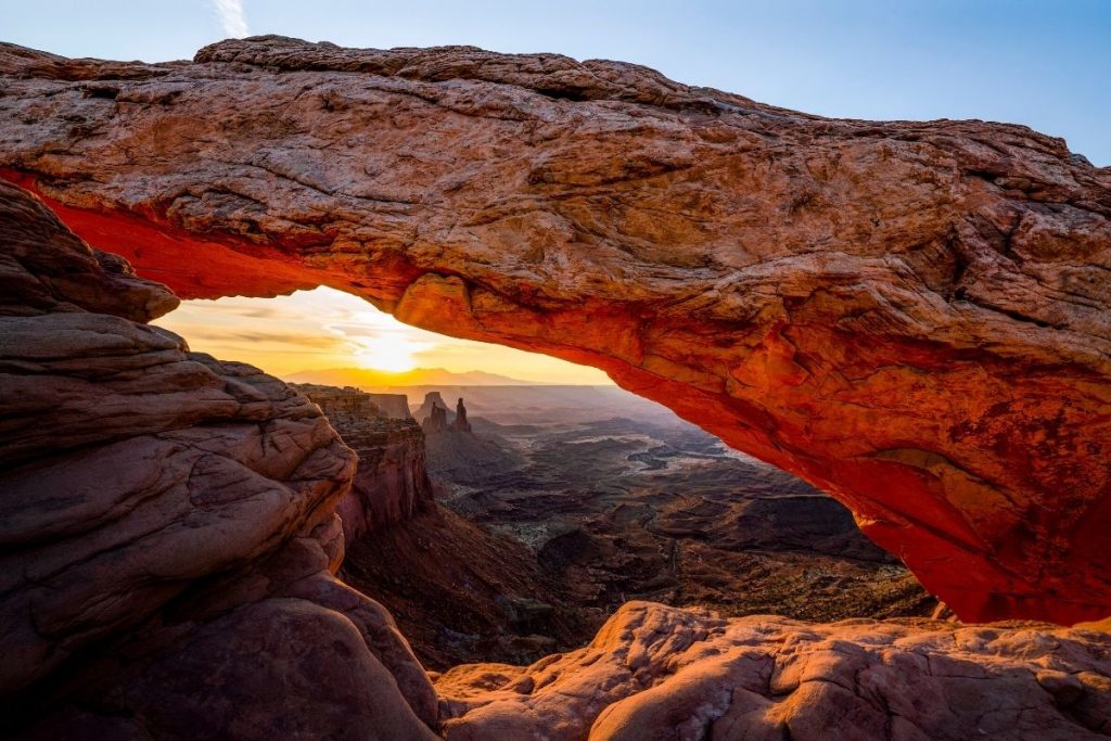 Mesa Arch at Sunrise with view of the distant valley