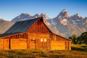 Sunrise illuminates a historic barn at Mormon Row in Grand Teton