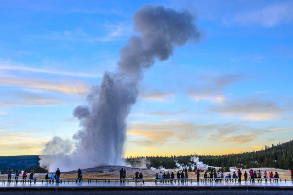 Early morning sunrise as Old Faithful erupts in Yellowstone